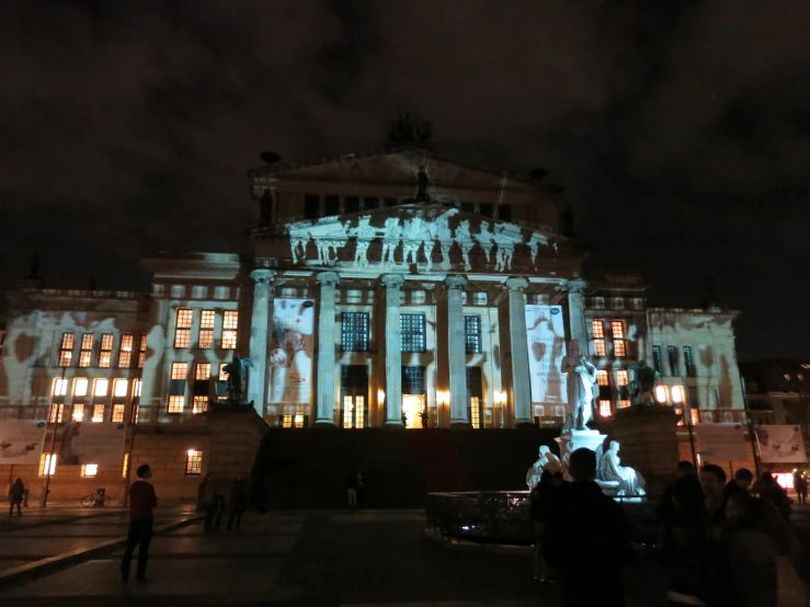 a large building with a clock on the front and people walking in front