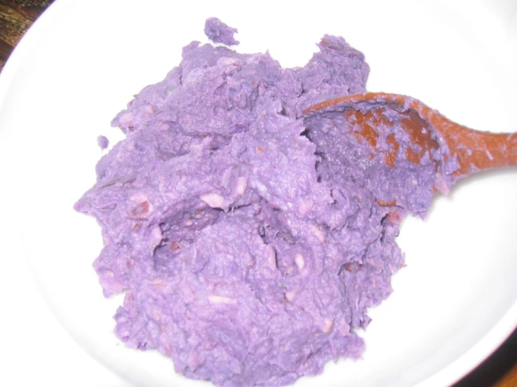 there is a spoon filled with a very purple substance