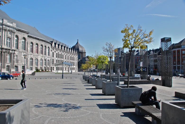 a man sitting on a bench next to tall buildings