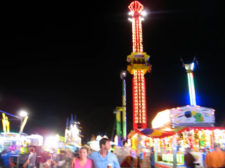 amut park fairgrounds at night with ferris wheel and rides