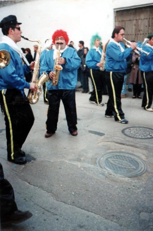 a band is dressed in blue, and they are playing on their instruments