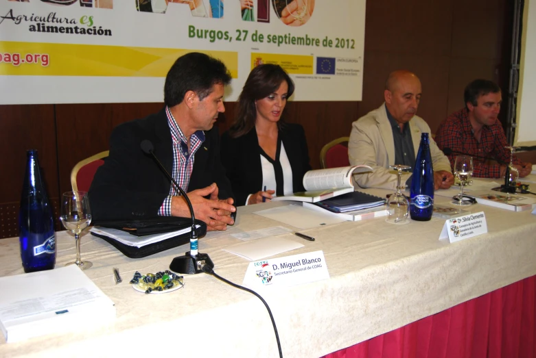 the man and women are seated at a conference table