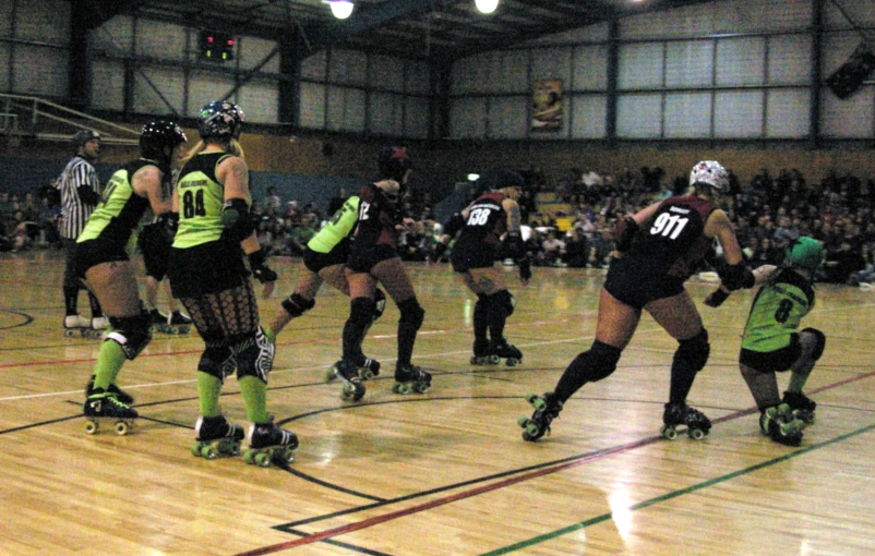 rollerblader in green and black are racing on the court