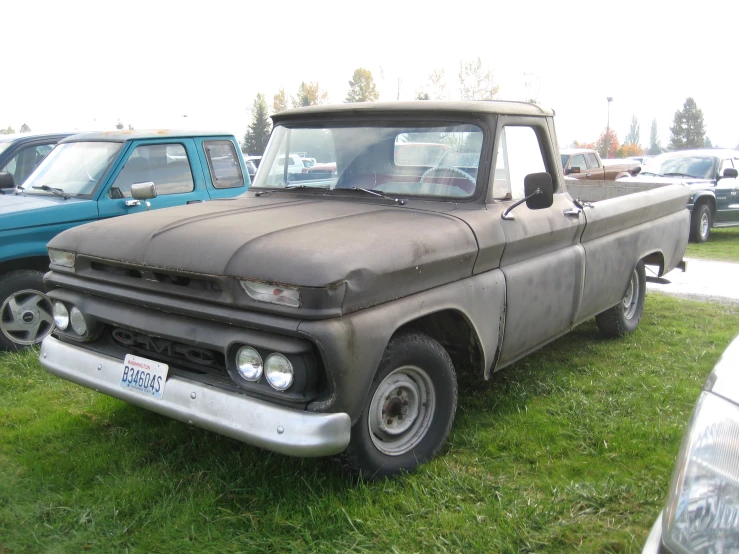 a very old pickup truck sitting in the grass