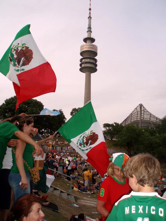 people are celeting at an event with mexican flags in the background