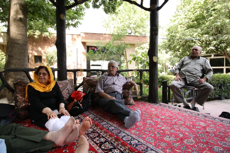 people sit on a patio with one man holding his baby