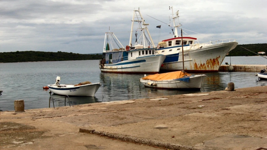 two small boats docked near the shoreline of a large body of water