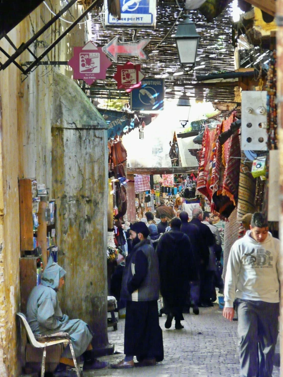 people walking on a street that has some signs and banners hanging