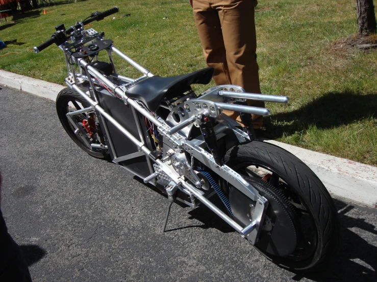 a motorcycle parked on the side of a road next to a man