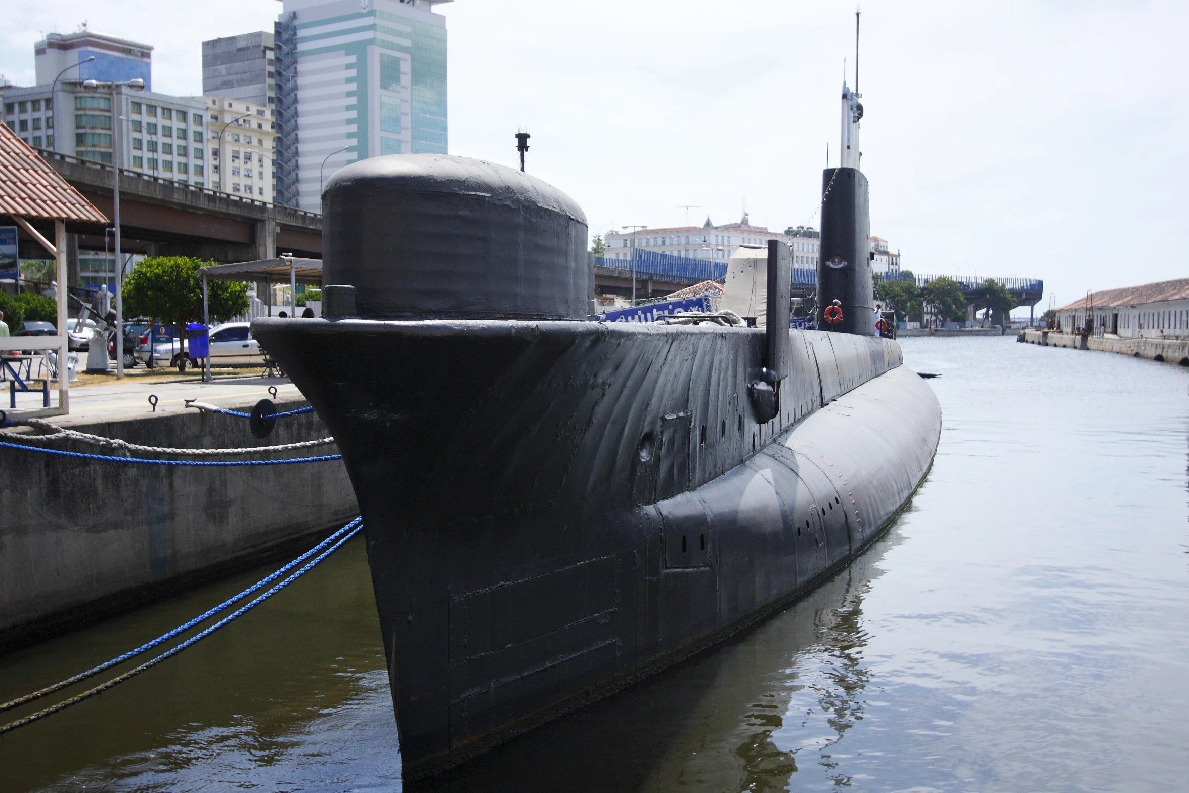 a submarine that is in some water and has two men standing next to it