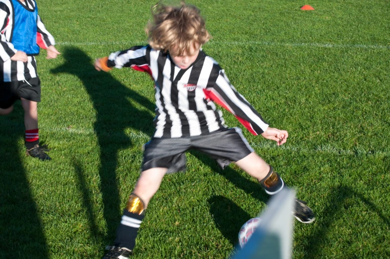  playing soccer with another person wearing a referee outfit