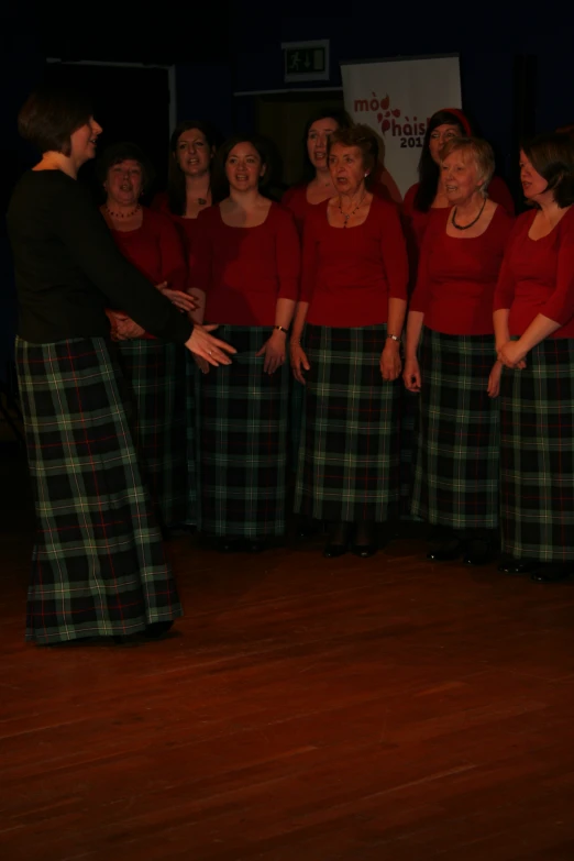 a woman in plaid skirt singing and smiling