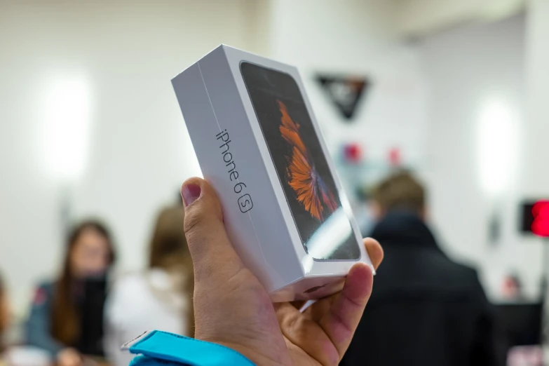 a person holding up a package for a book