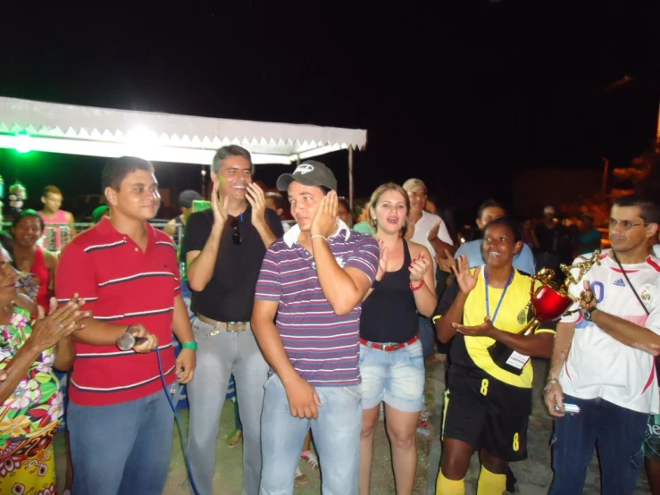 many people are standing together on the beach