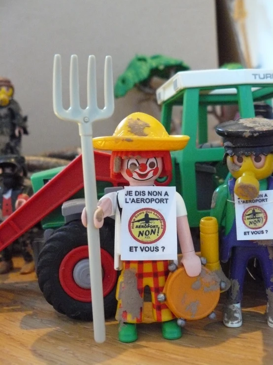 a small toy man with a shovel and sign in hand