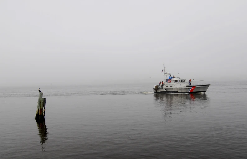 the boat is traveling in to land and it appears to be raining