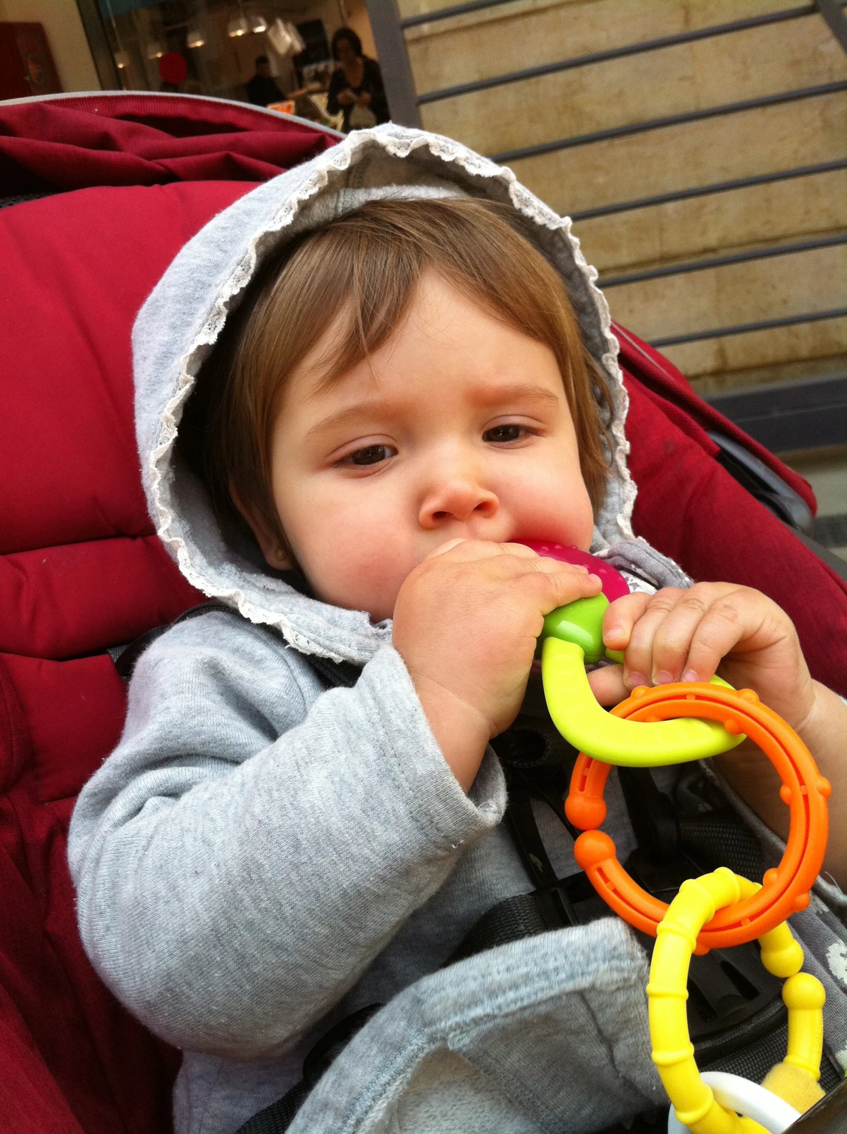 a little boy sitting in a baby seat with a toy