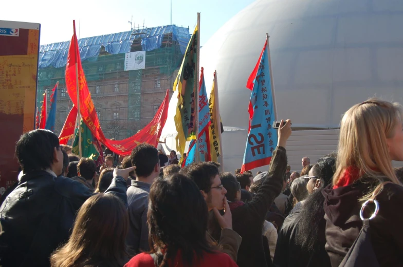 a group of people standing around holding signs and banners