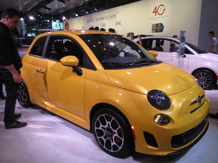 a yellow car sitting next to a couple of other cars