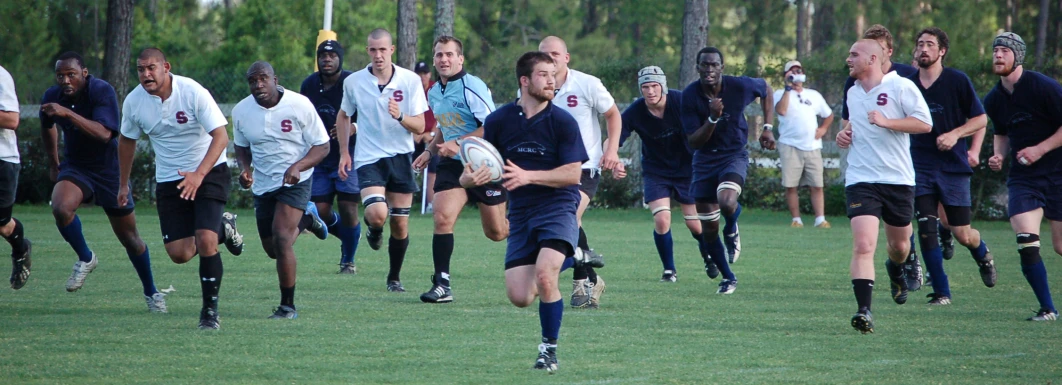 people are running in the field and one person is throwing a ball