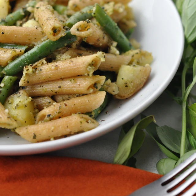 a plate full of pasta and vegetables is next to a fork