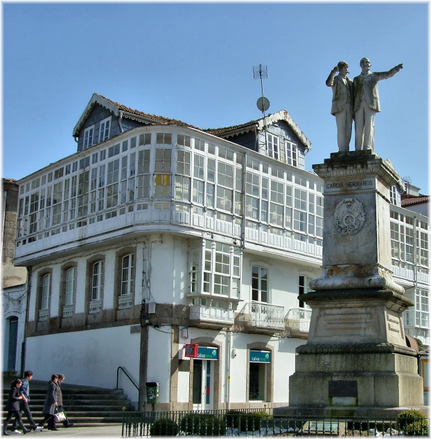the statue is in front of an ornate white building
