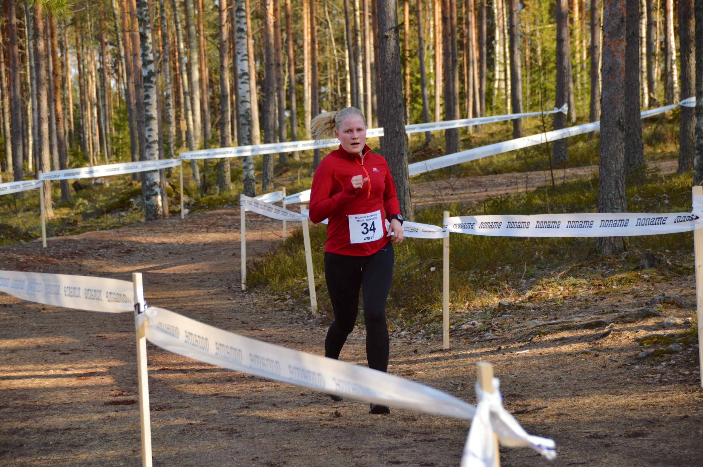 a person running around the course with a red jacket