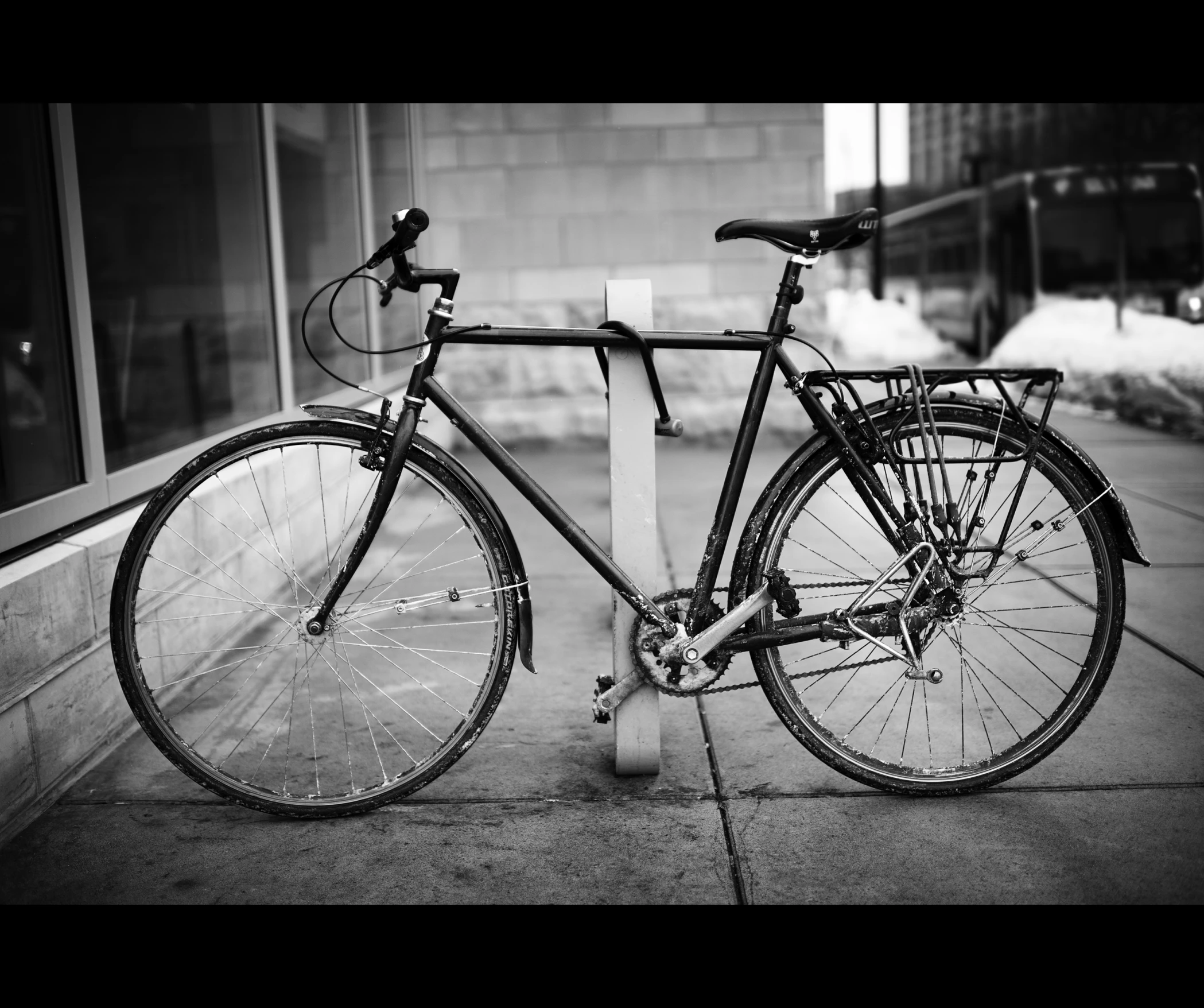 a bike is  to the pole in front of a building