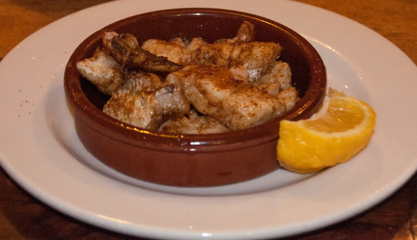 a bowl filled with food and lemon slice