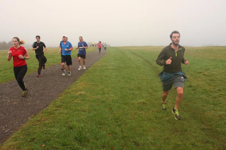 a group of people running on a wet trail