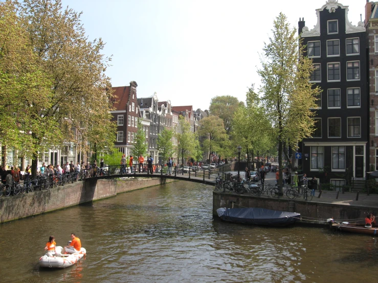 a group of people in a boat near a bridge