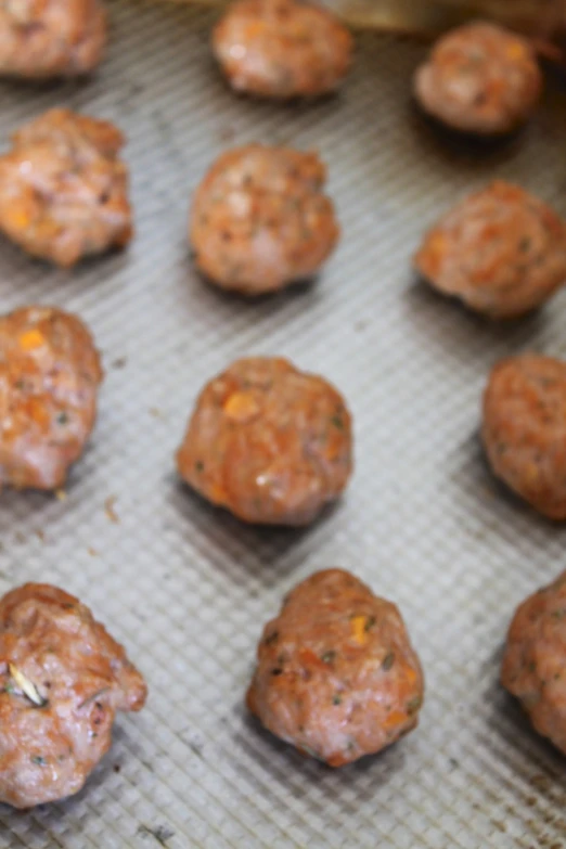 meat balls are sitting on a baking sheet