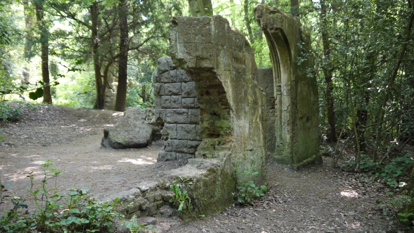 a stone arch in the middle of the woods