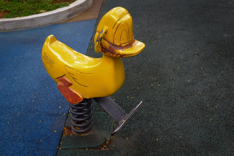 an animal like chair on the playground near a children's play area