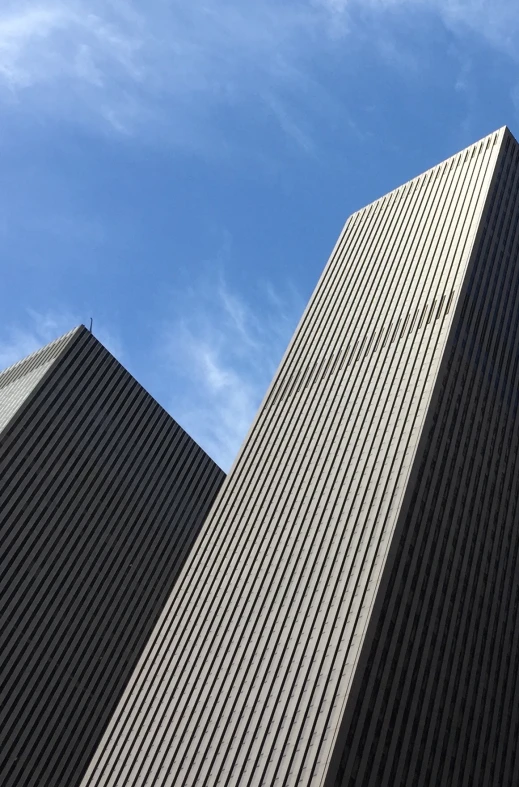 view from below of modern skyscrs looking up at sky