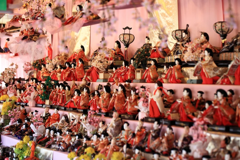 many dolls and figurines are arranged on display