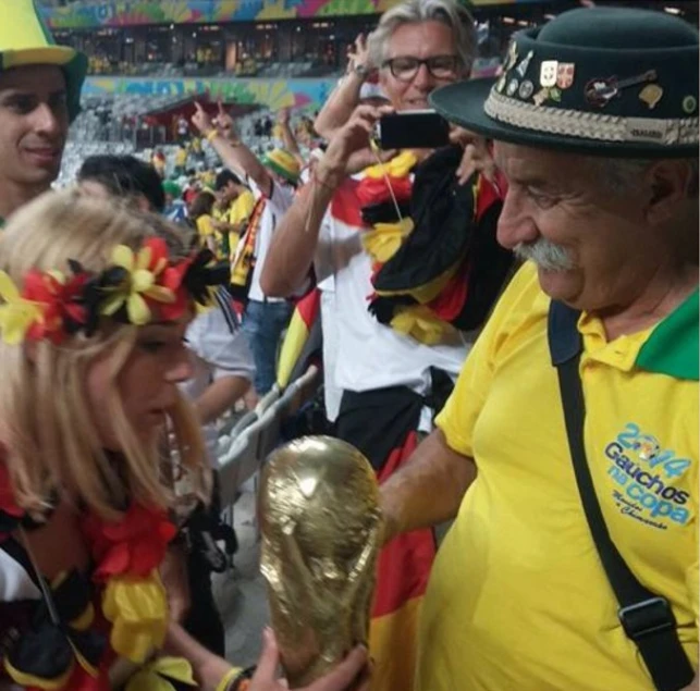 two women are holding the world cup and watching a soccer game