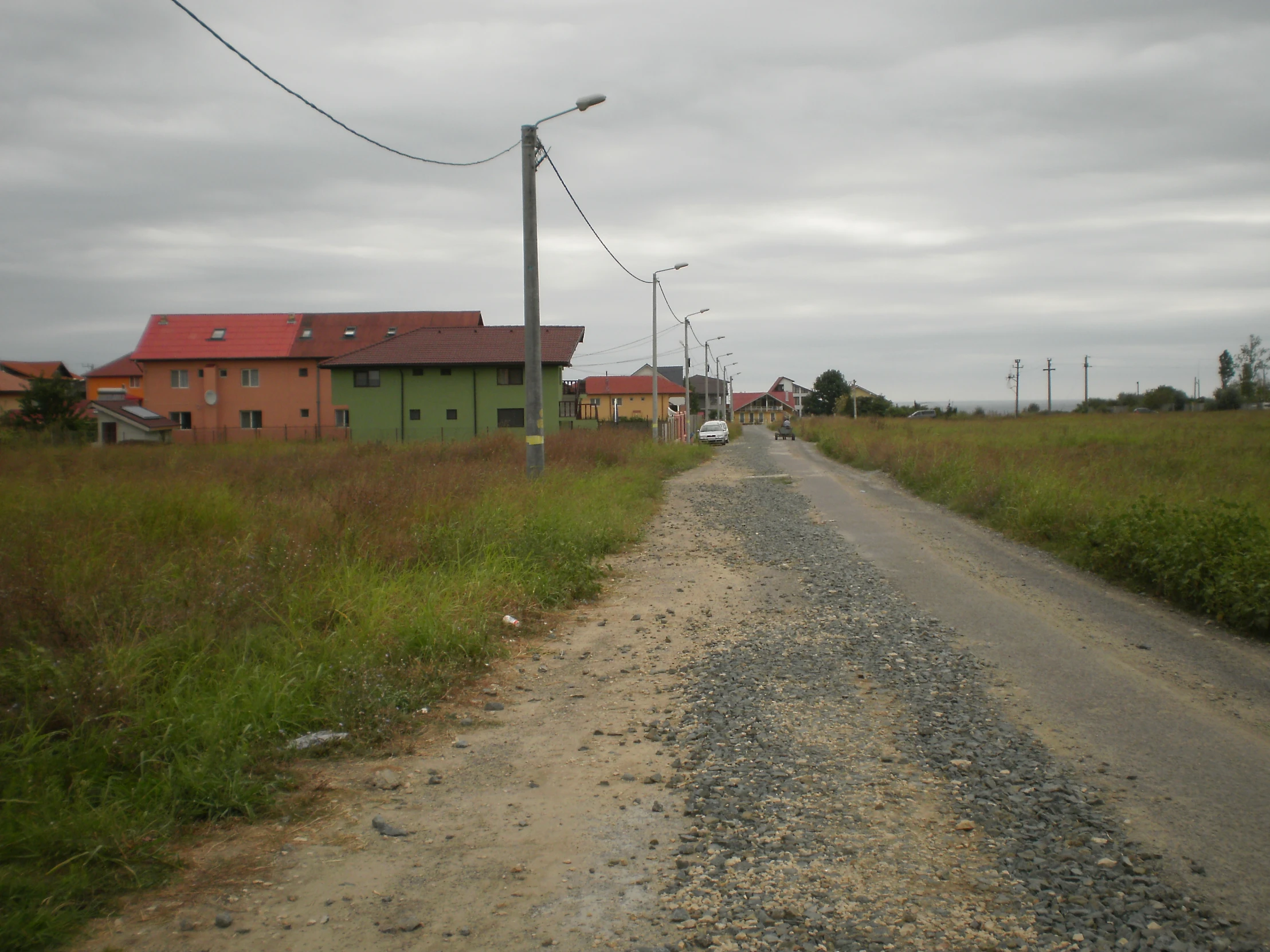 a dirt road passing through an empty field