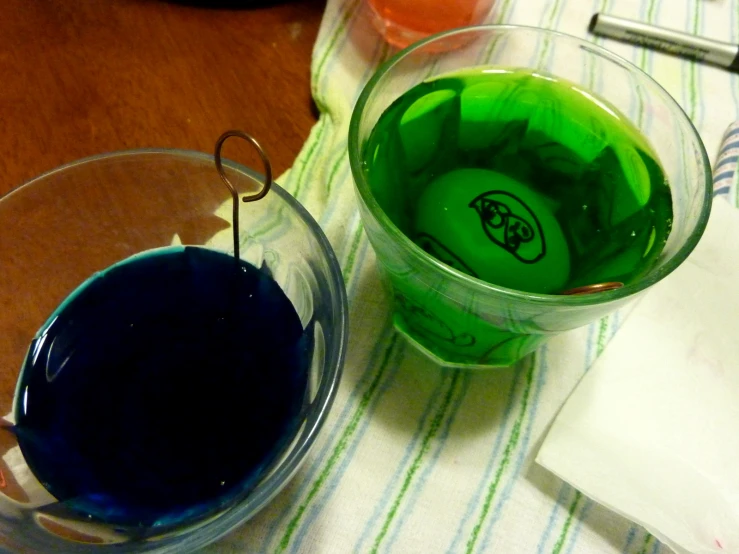 two different colored liquids sit inside small cups