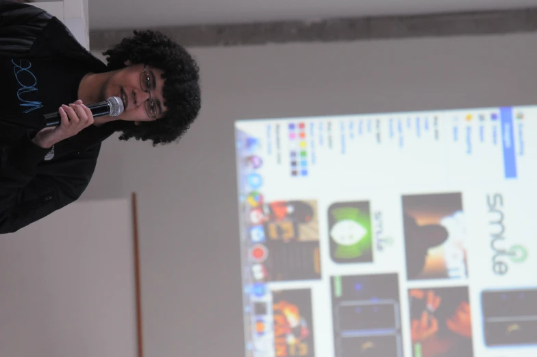 a young man is holding a microphone up to the camera