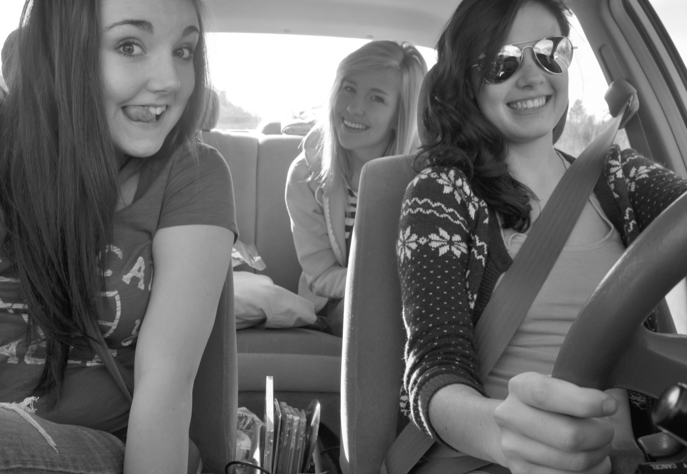 three women sitting in the back of a car