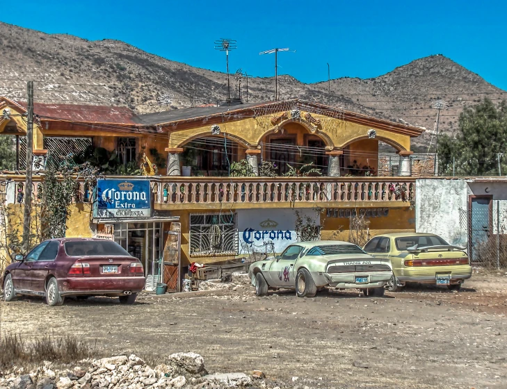 three cars parked outside a house near mountains