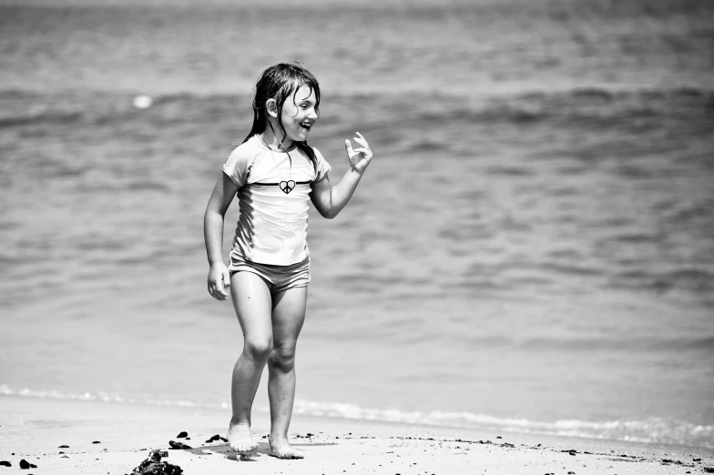 a little girl walking along the beach near the water