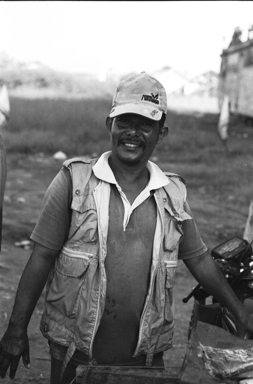 an older man holding a metal object near a wooden crate