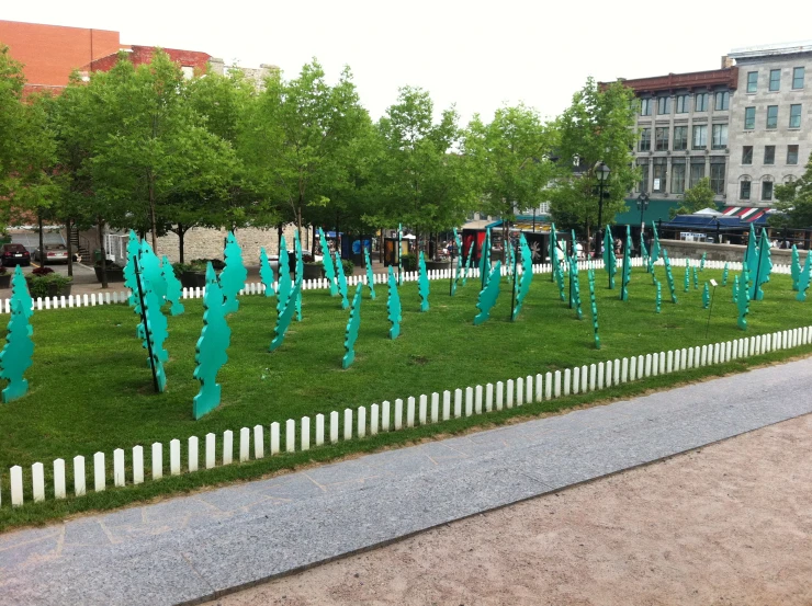 several blue pieces of paper on the grass in front of buildings