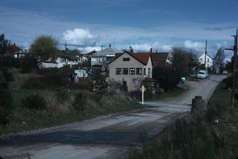 a dirty road and old houses sitting on top of it