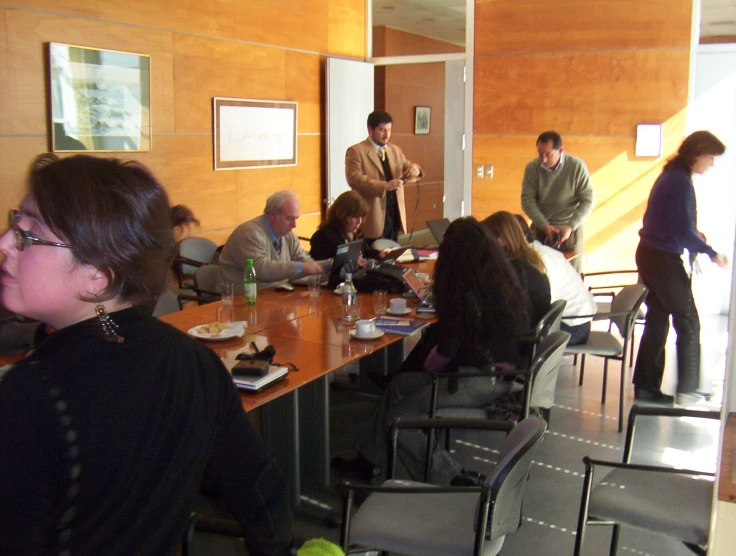 a group of people gathered around a long table eating and drinking