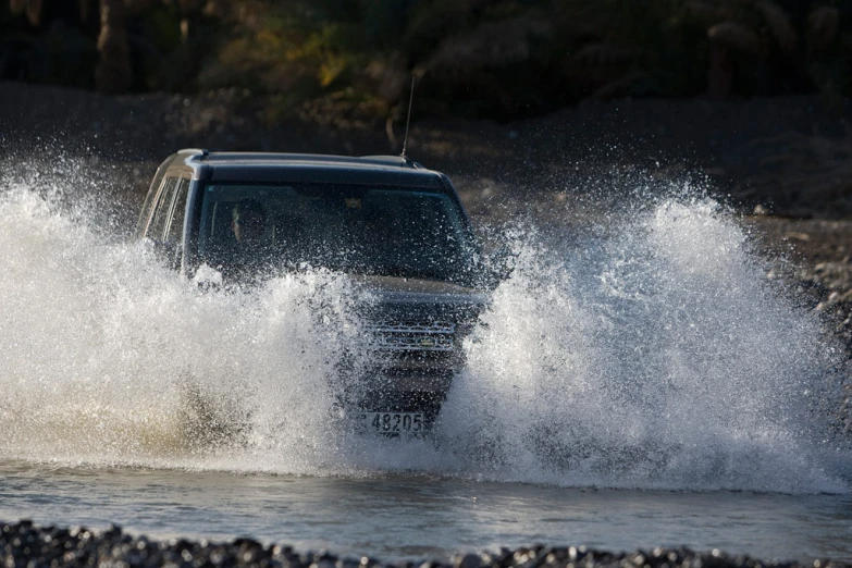 the truck is moving through a rough body of water