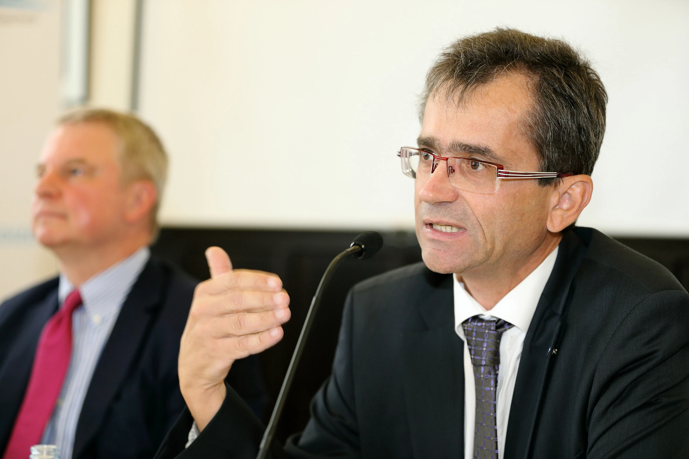 two men sitting at a table wearing glasses