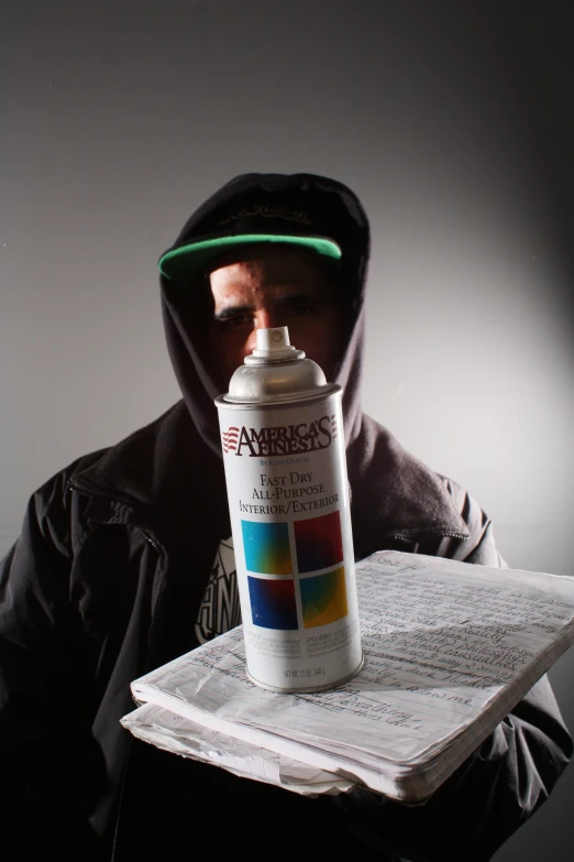 a person holding a spray bottle over an open book